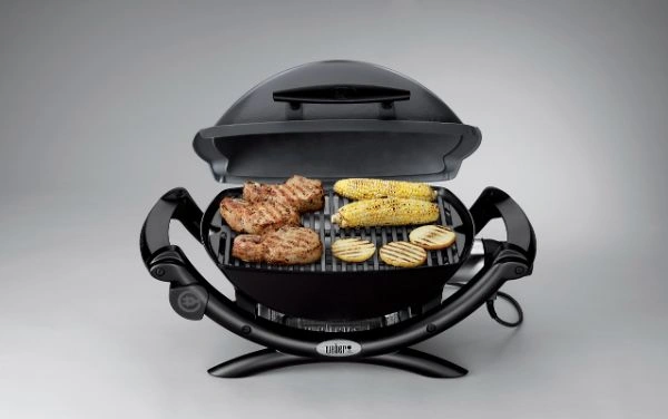 Bucati de carne, porumb si felii de cartofi pe gratar electric Weber Q1400